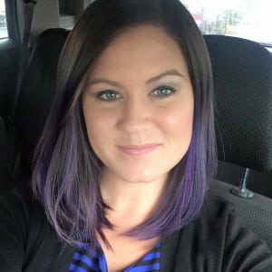 A portrait of Sierra Royster. She has shoulder length dark hair with purple ends. She is sitting in her car with the headrest behind her left shoulder.
